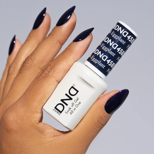 Hand holding a DND nail polish stick with 'Eggplant' color on a gray background